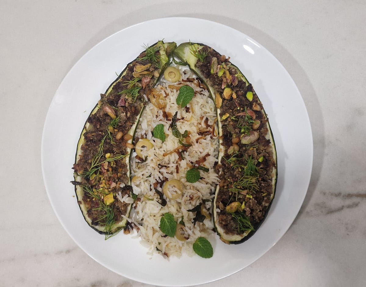 Zucchini filled with minced beef, rice with caramelized onion and green herbs